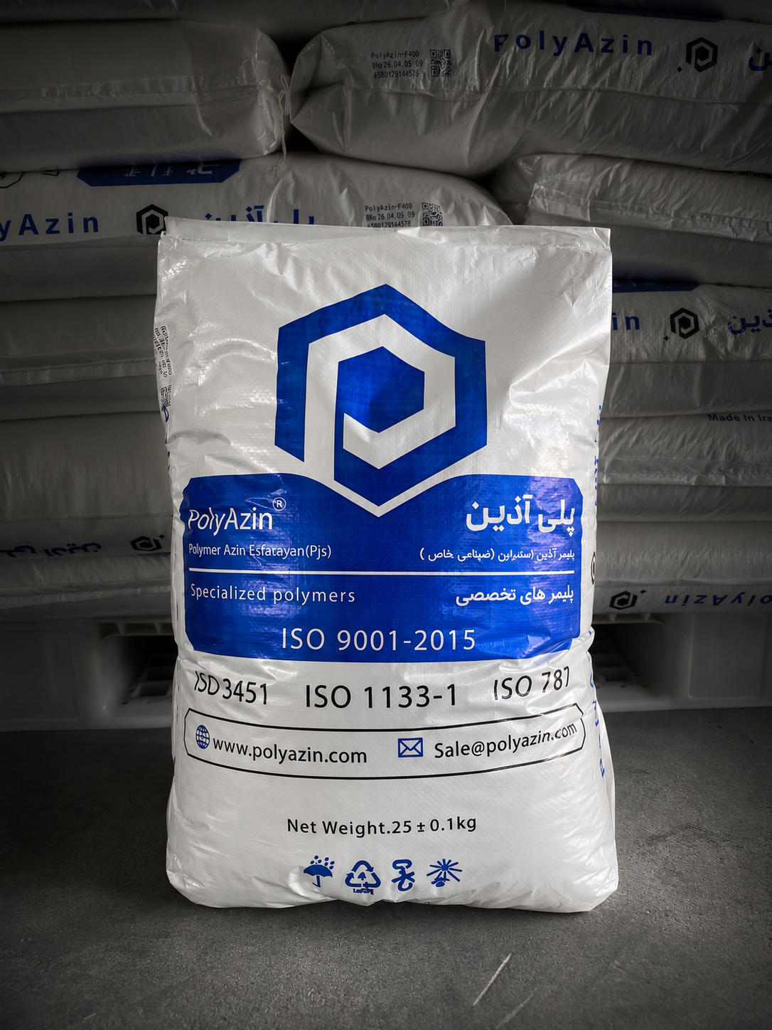 A branded PolyAzin 25 kg bag with printed batch number, QR code and ISO standards, in front of stacked pallets in the warehouse
